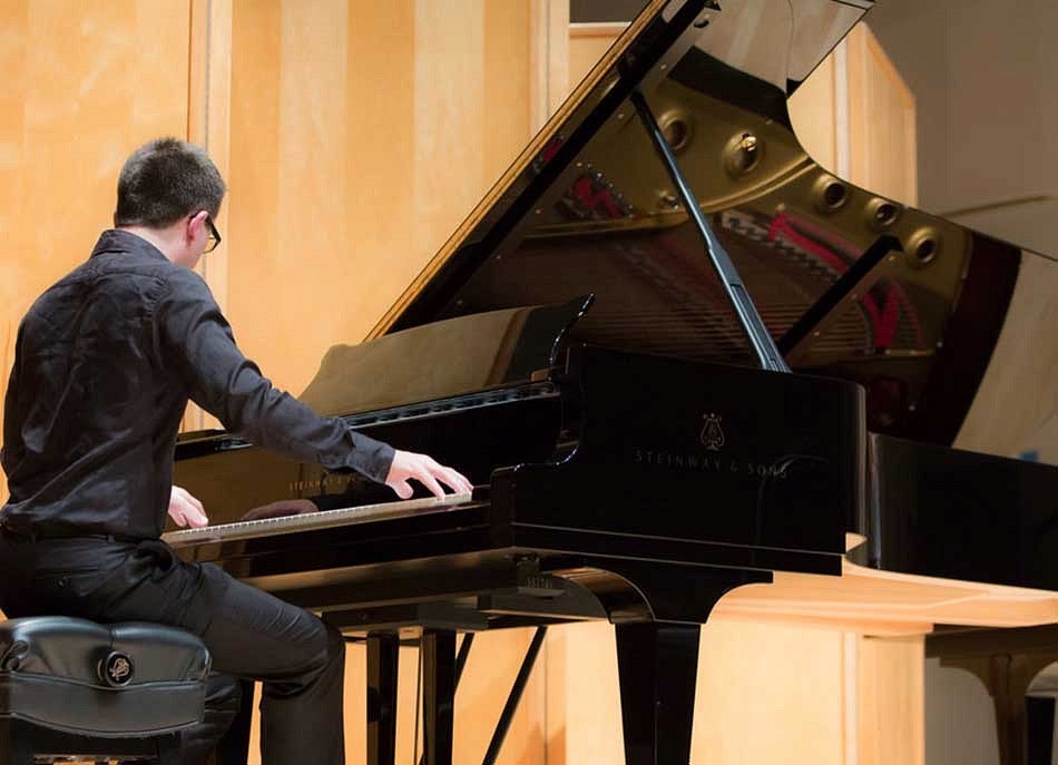 A person playing a piano on a stage A person playing a piano on a stage