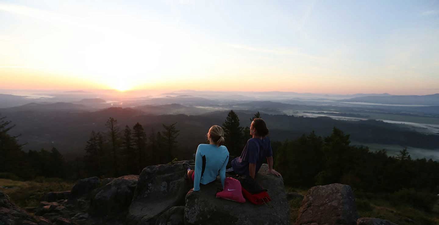 Two people sitting on the top of Spencer Butte overlooking the Willamette Valley Two people sitting on the top of Spencer Butte overlooking the Willamette Valley